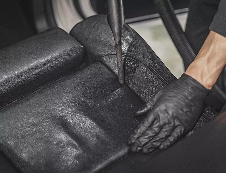 A Man Cleaning the Car Back Seat with vacuum cleaner