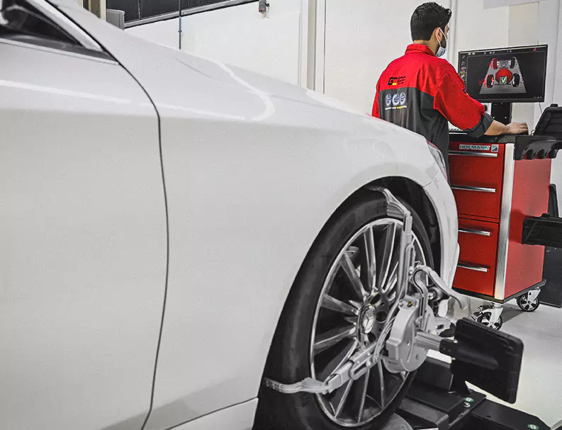 A German Expert Checking The White Car Tyres Allignment on Computer Screen