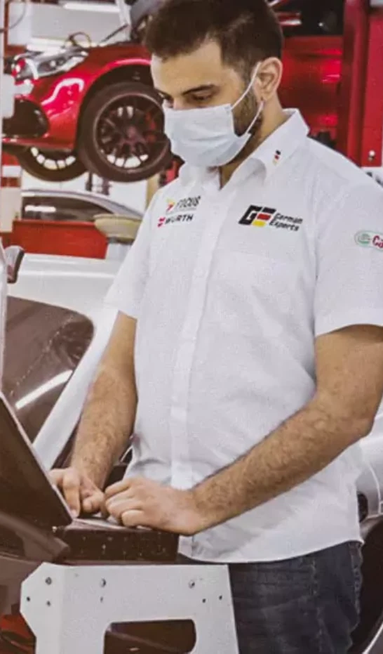 German expert checking car transmission problems on laptop