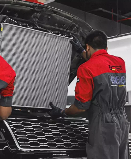 Two German Experts Holding the Car Radiator to Fix in the Car