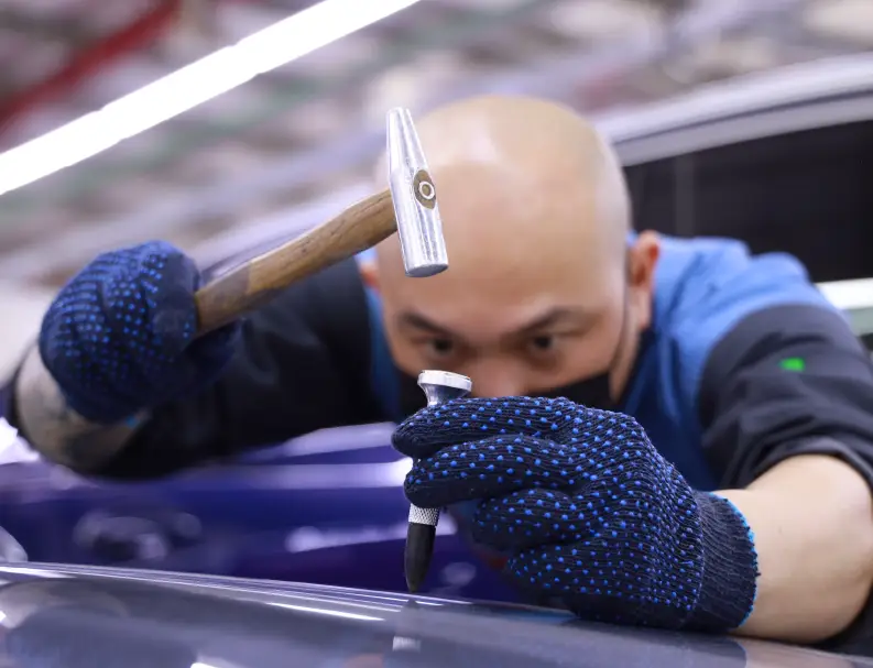 A Man Repairing Dent from Car Bonnet